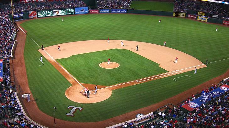 A baseball stadium with a game being played and fans watching