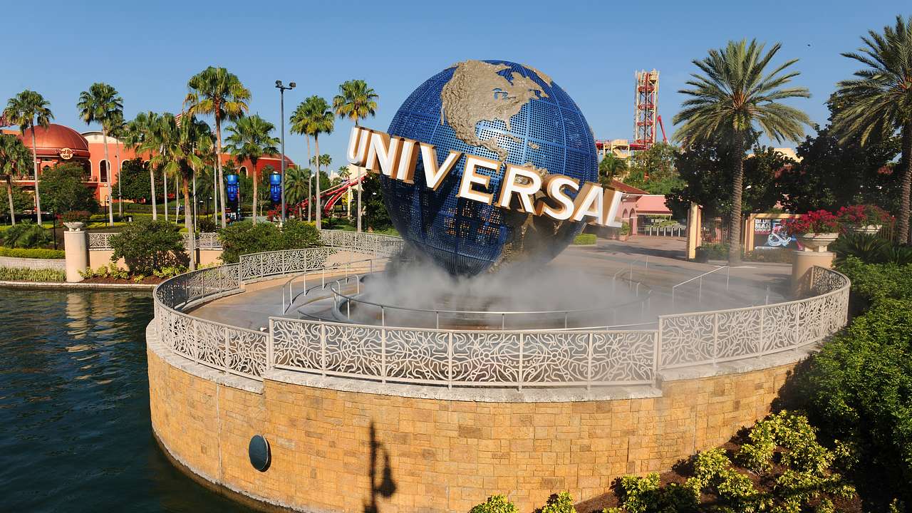 A replica of a globe in the middle of a fountain with a logo saying "Universal"