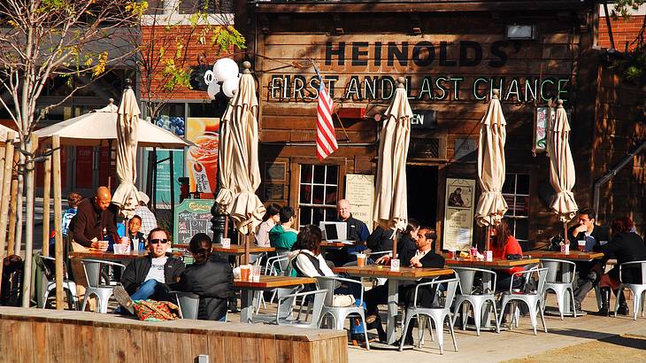 A restaurant with people sitting at tables outside