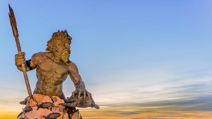 A stone statue of a man with a trident