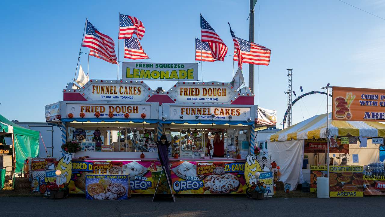 Fair-ground food stands with American flags on top of them