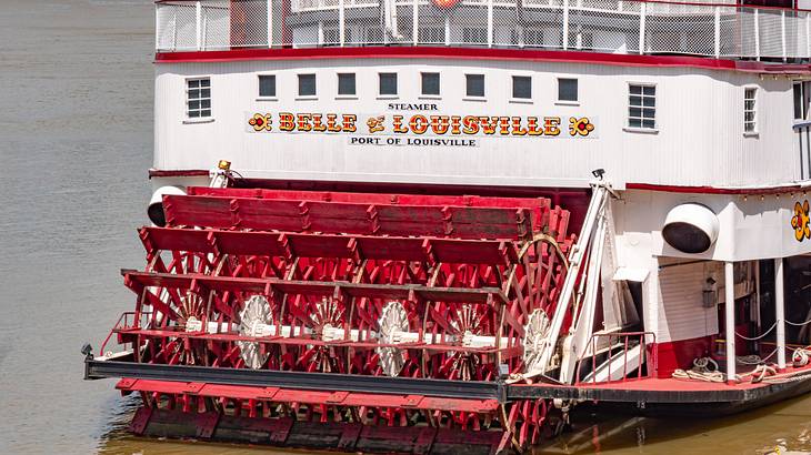 A red and white paddle boat with a "Belle of Louisville" sign