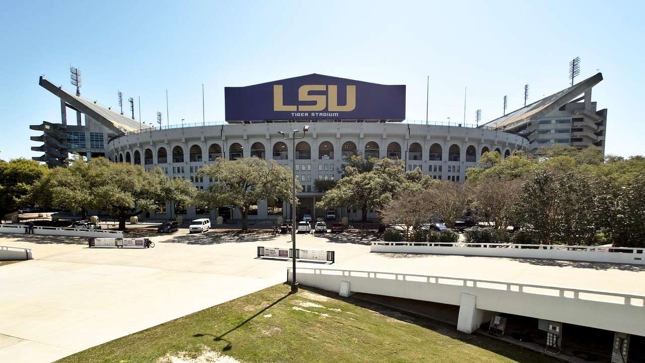 A football stadium with a sign that says "LSU" next to a road and grass