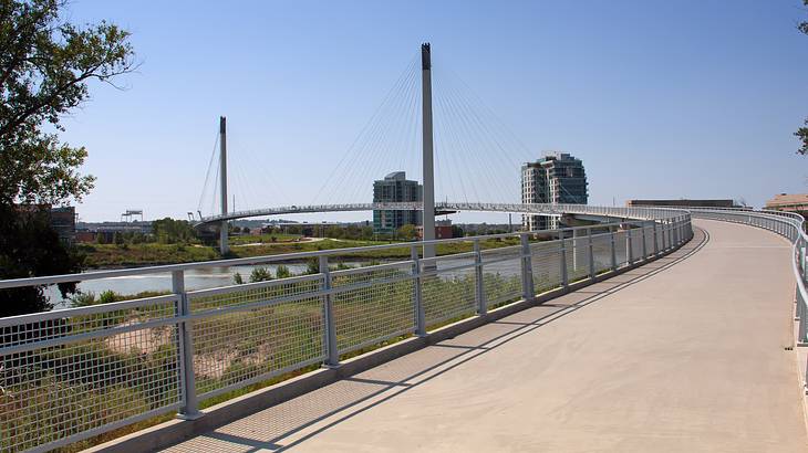 A long and empty suspended bridge walkway under a blue sky