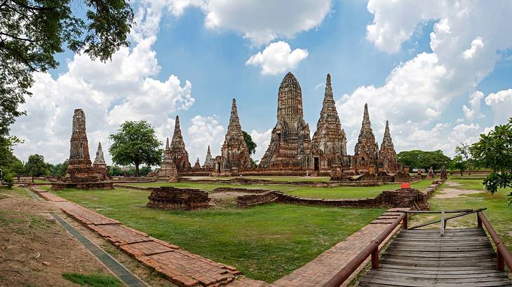 Wide angle view of temple ruins with green lawns and trees around