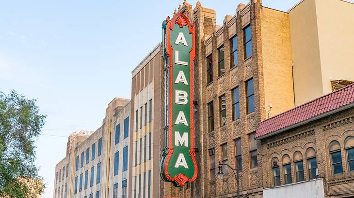 A red, white, and green sign that says "Alabama" on a brick building