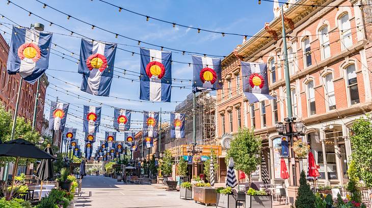 An alleyway of buildings with outdoor patios decorated with hanging banners