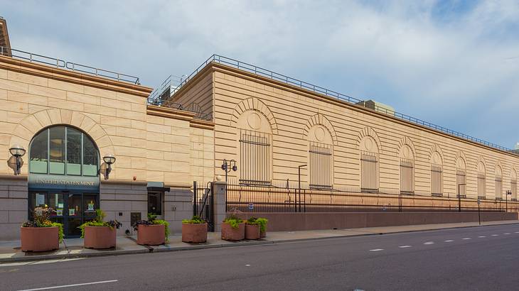 A brick building with barricaded windows and a "United States Mint" sign