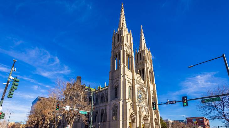 A Gothic-style church with two tall spires under a blue sky