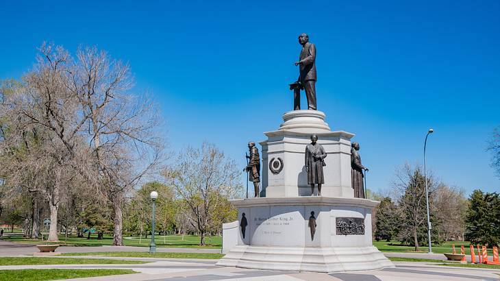 Bronze statues of people on a white pedestal