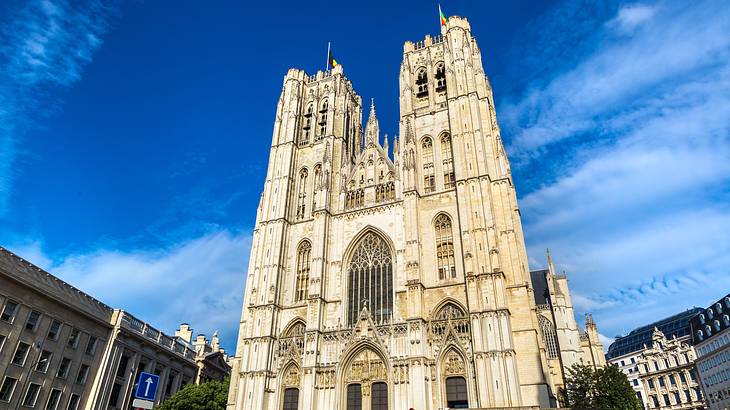 Looking up at a Gothic cathedral building against a partly cloudy sky