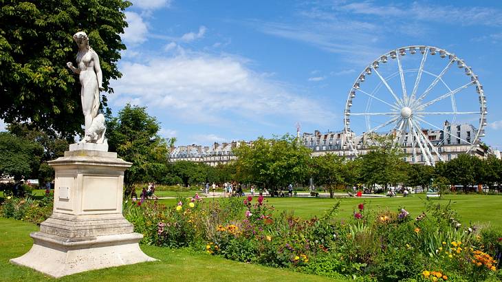 A garden with a statue, Ferris wheel, flowers, and trees under a blue sky