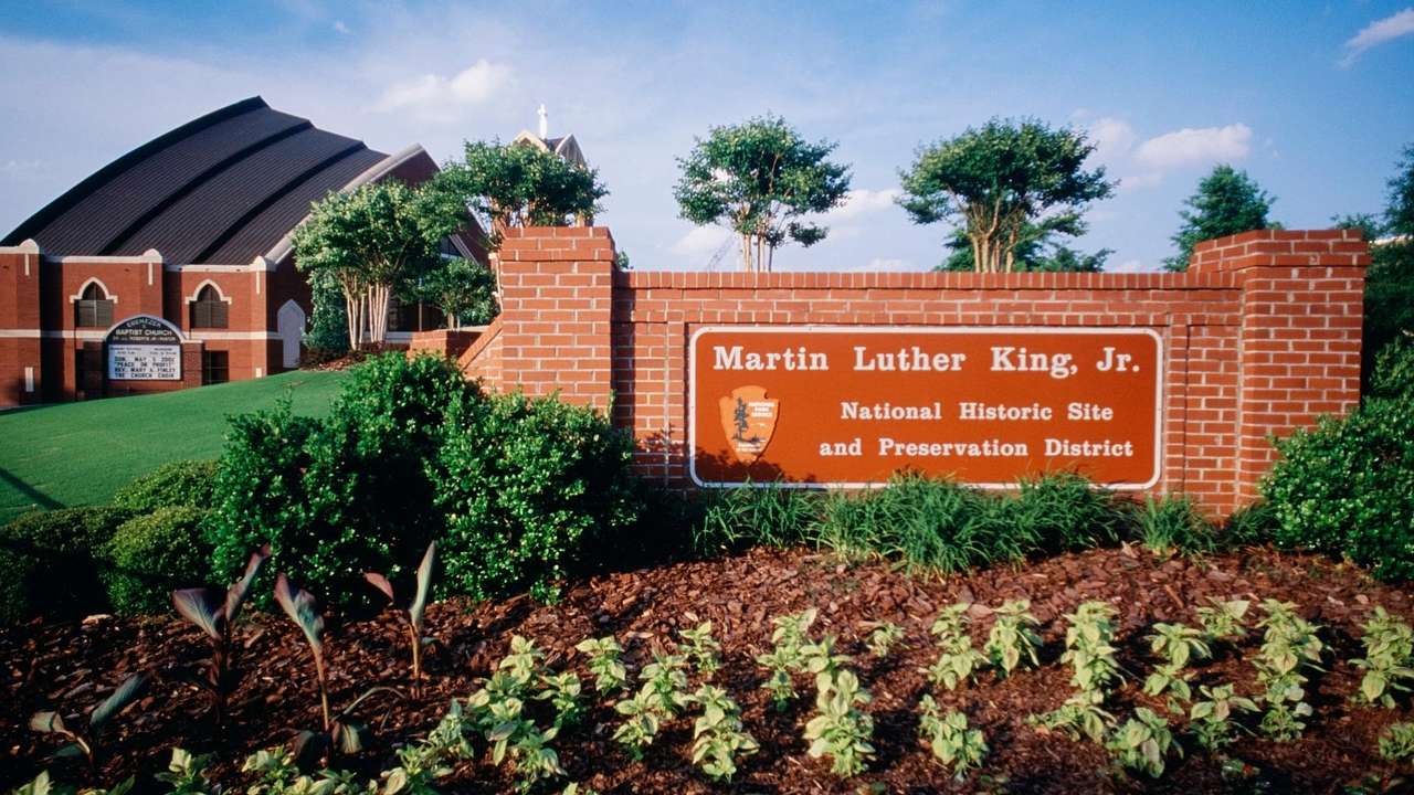 A building and brick wall with a "Martin Luther King Jr. National Historic Park"