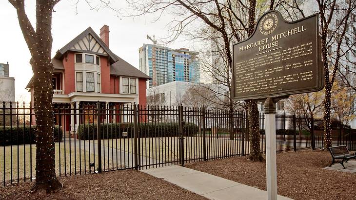 A red brick and white house with a "Margaret Mitchell House" sign in front of it