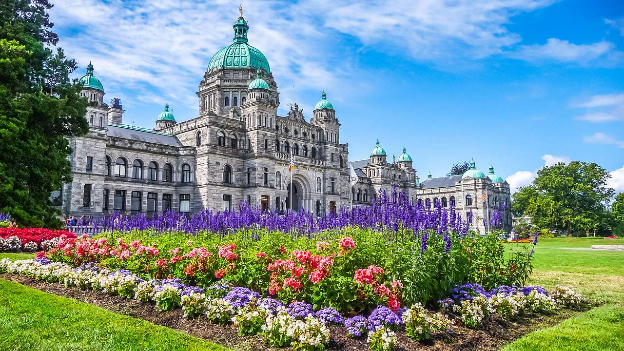 Historic building under the blue sky with colorful flowers in the foreground