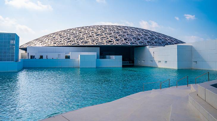 Contemporary museum surrounded by blue sky and serene waters