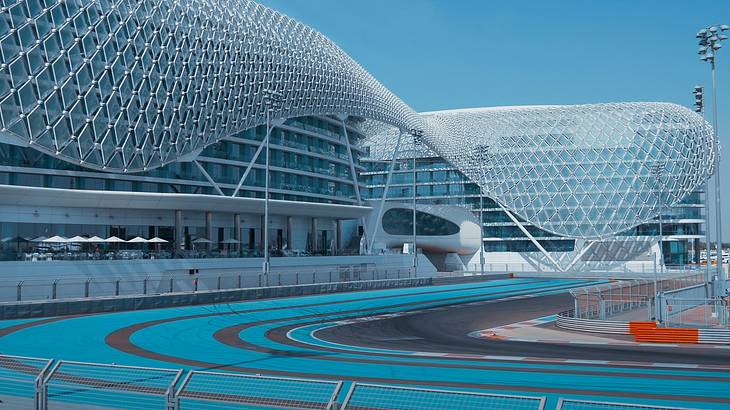 Expansive buildings mostly made up of glass and steel with a blue track in front