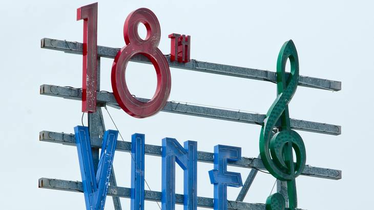 A store sign that has a G-clef and reads "18th Vine District"