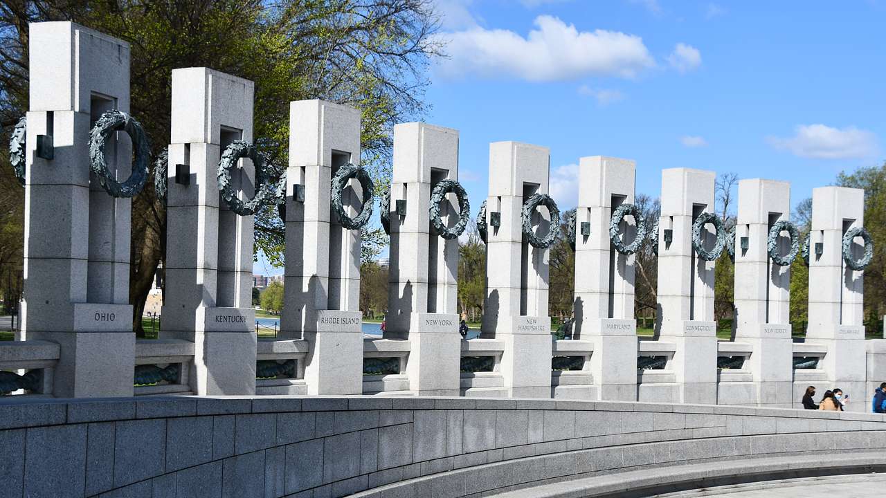 White concrete pillars with hanging concrete wreaths lined up