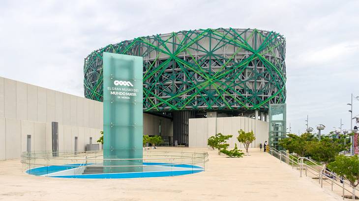 A contemporary building with a green pattern next to a glass sign