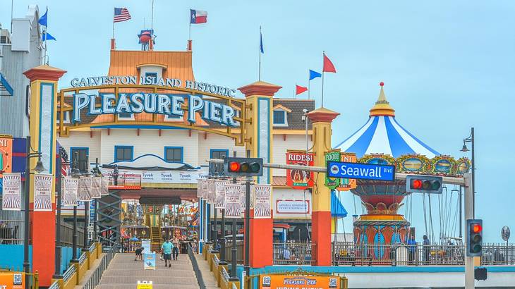 A colorful amusement pier with a "Pleasure Pier" sign