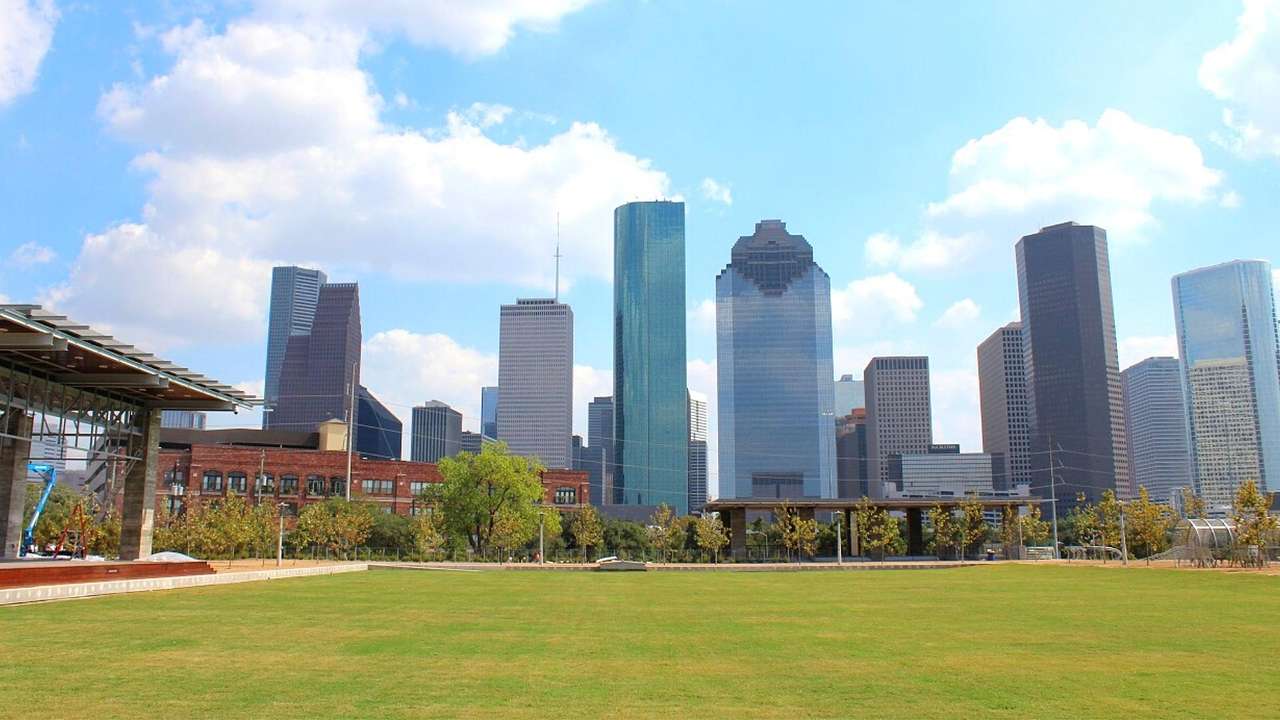 Skyscrapers with grass and trees in front of them