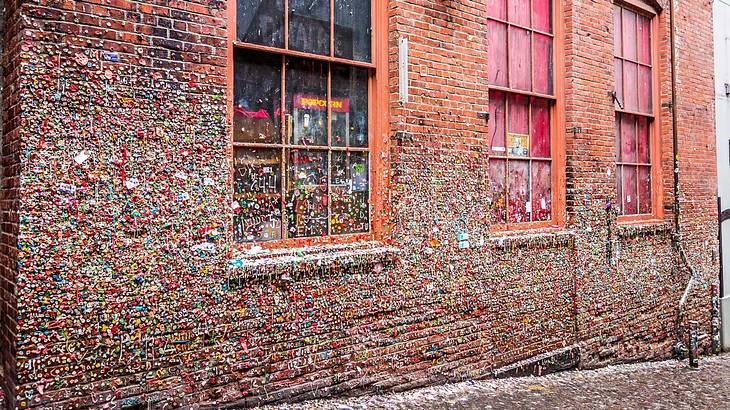 A building with three windows that's covered in colorful chewing gum