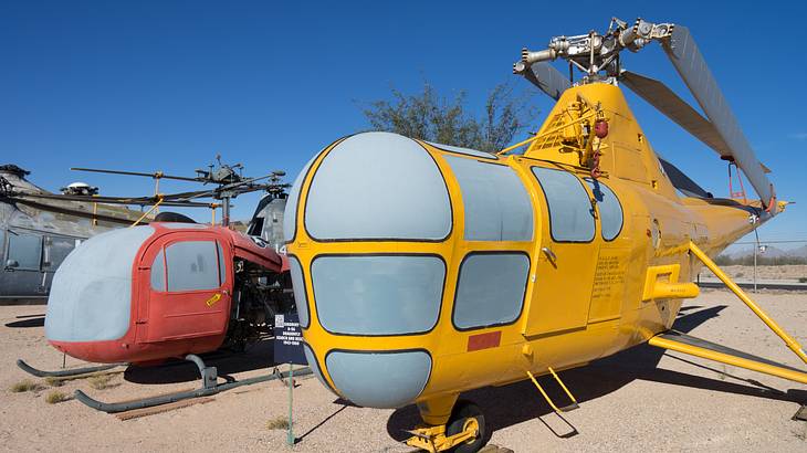 Red and yellow vintage aircraft on a sandy open area