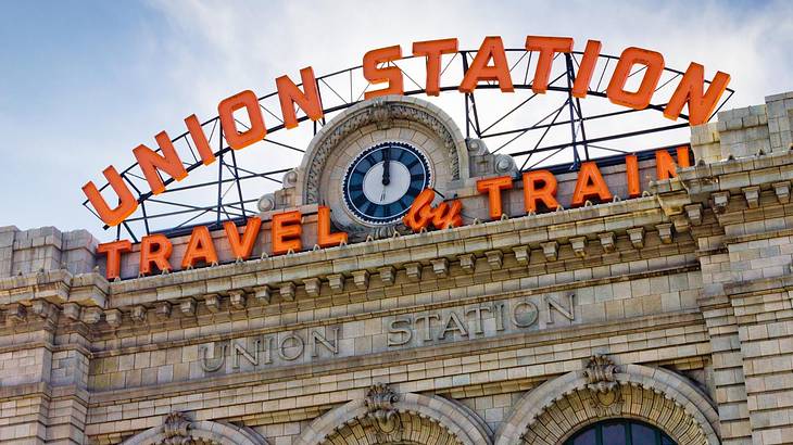 A stone building with an orange sign that says "Union Station Travel & Train"