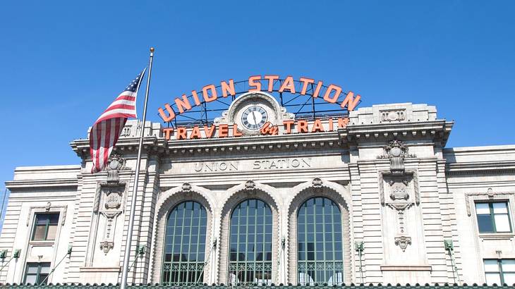 A stone building with glass windows and a "Union Station" sign on it