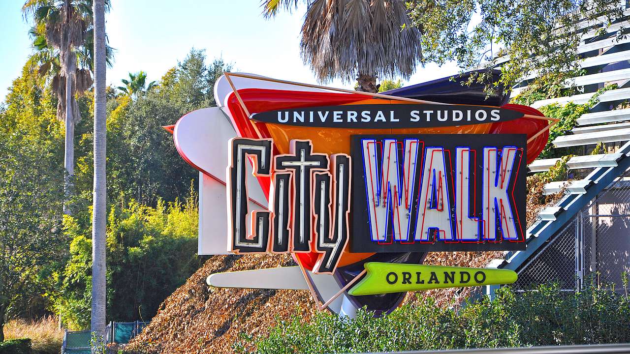 A sign that says "Universal Studios Citywalk" with trees at the back on a sunny day