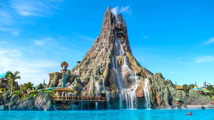 A replica of a volcano with water gushing from its top into a pool below