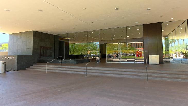 Looking towards stairs leading to the glass door entrance of a museum