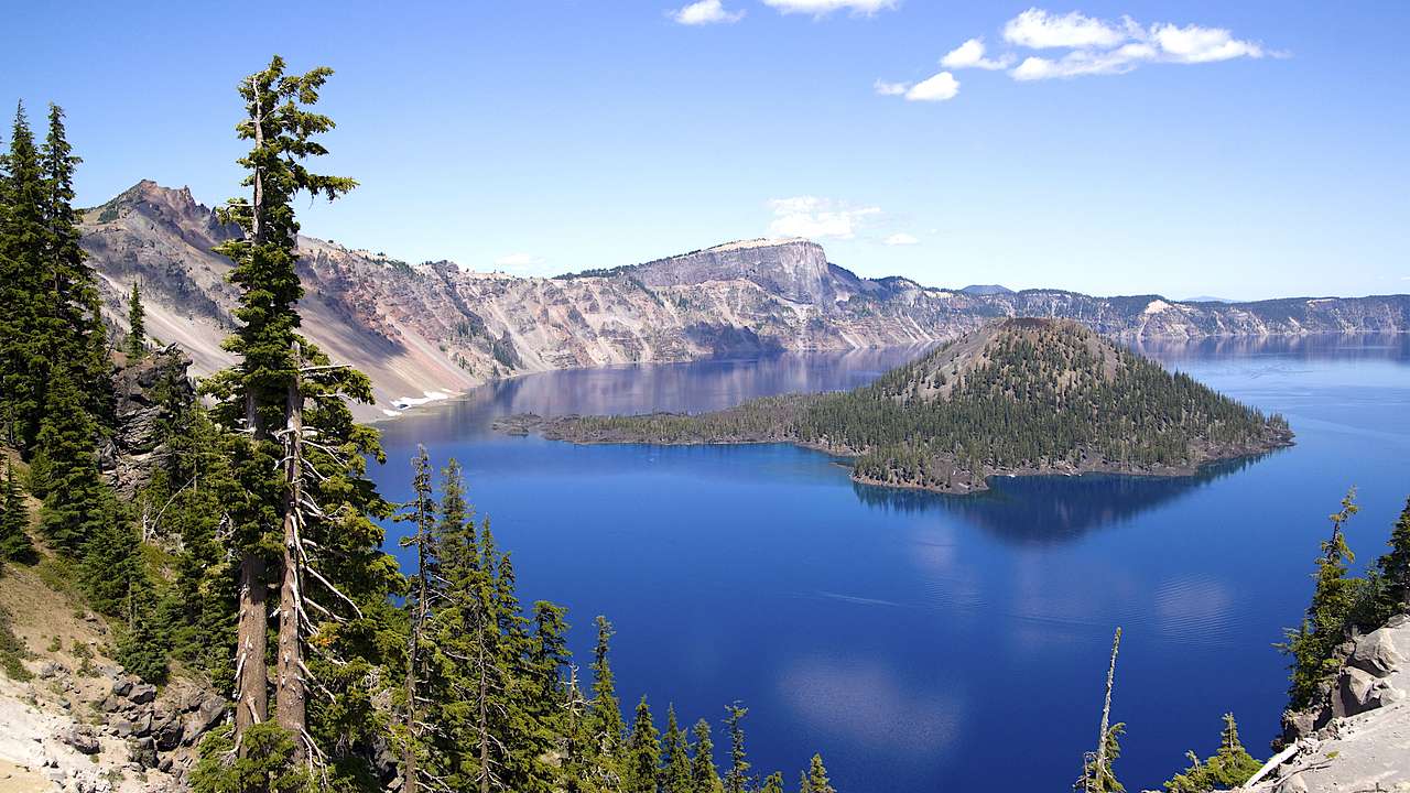 Mountains with trees surrounding a blue lake with an island in the middle