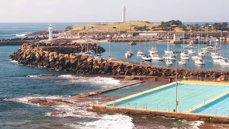 View of pools, water, a marina with boats and rocks, Wollongong, NSW, Australia