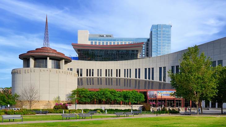 A building with a rotunda building attached and grass and trees in front of it