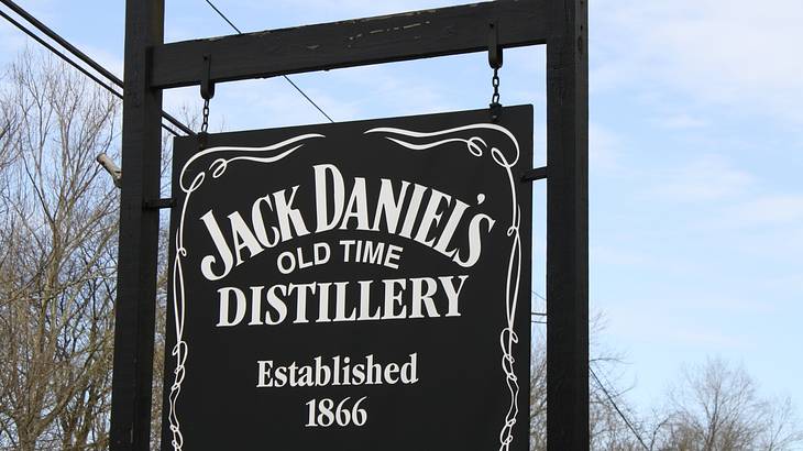 A black sign that says "Jack Daniel's Old Time Distillery Established 1866"