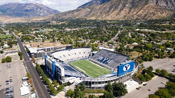 An ariel view of a blue football stadium surrounded by greenery and mountains