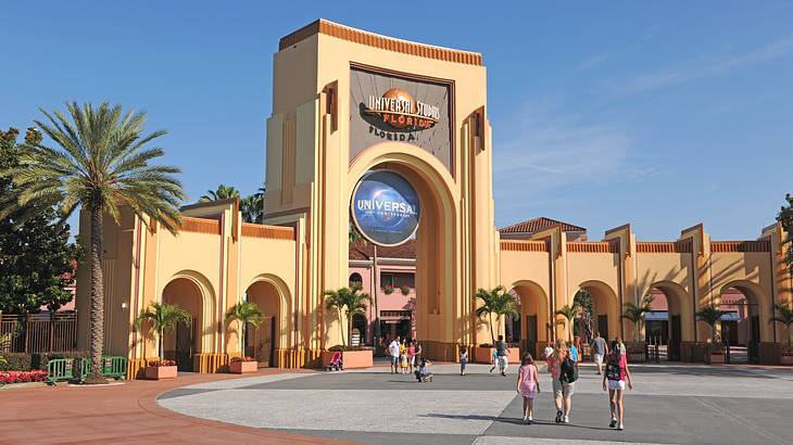 An arched entryway that says "Universal Studios Florida" with palm trees next to it