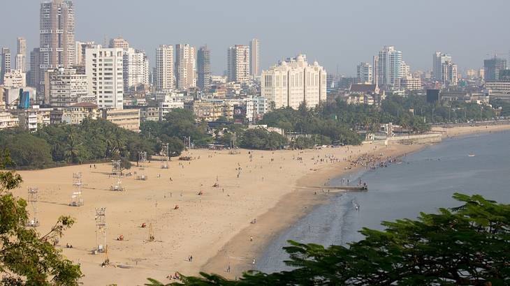 Top view of a beach along the coast of a city with many buildings