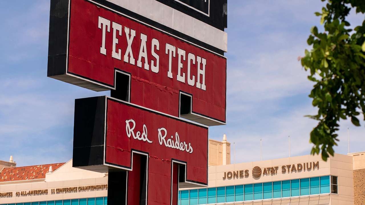 A red sign that says "Texas Tech Red Raiders" next to a building