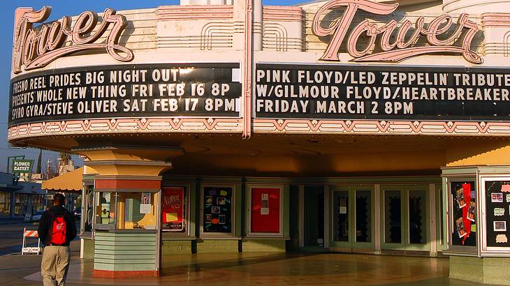 A theater with a marquee, a box office, and a tall spire in the middle