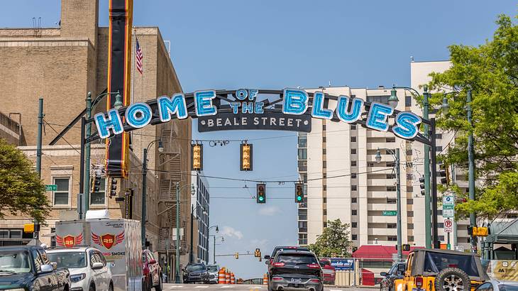 A road with cars and a welcome sign saying "Home of The Blues, Beal Street"