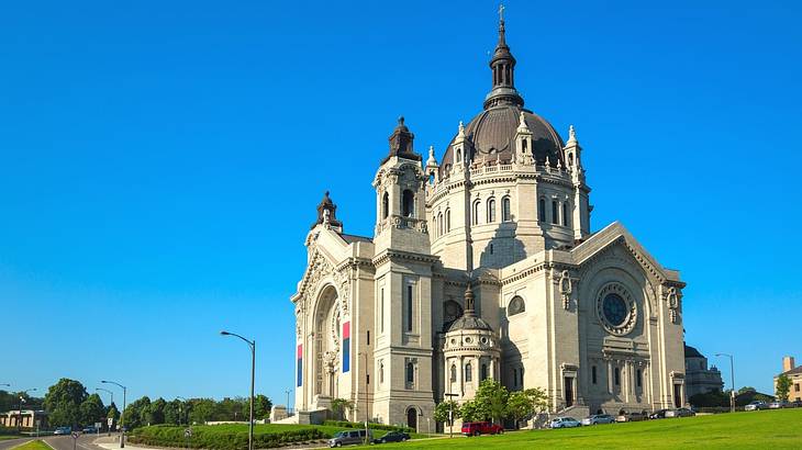 A stone cathedral sitting on the grass under a clear blue sky