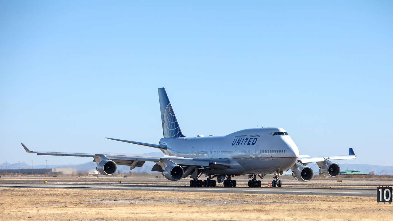A huge airplane on a runway under a clear, blue sky on a sunny day