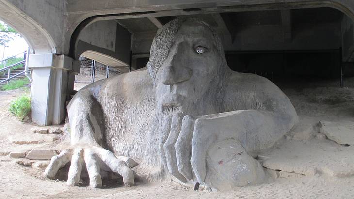 A large sculpture of a troll under a bridge
