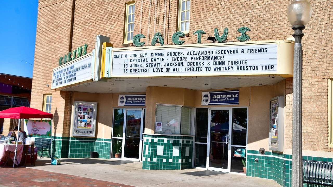 The exterior of a theater with a performance schedule and "Cactus Theater" sign