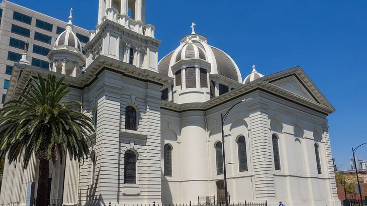 A white cathedral with a bell tower and a dome in the middle