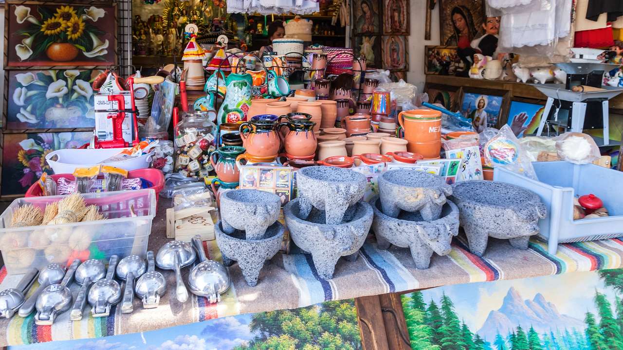 A market stall with pottery and paintings behind it