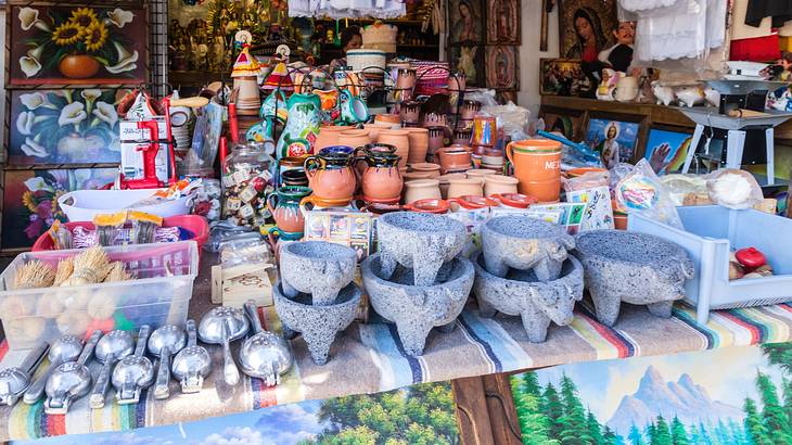 A market stall with pottery and paintings behind it